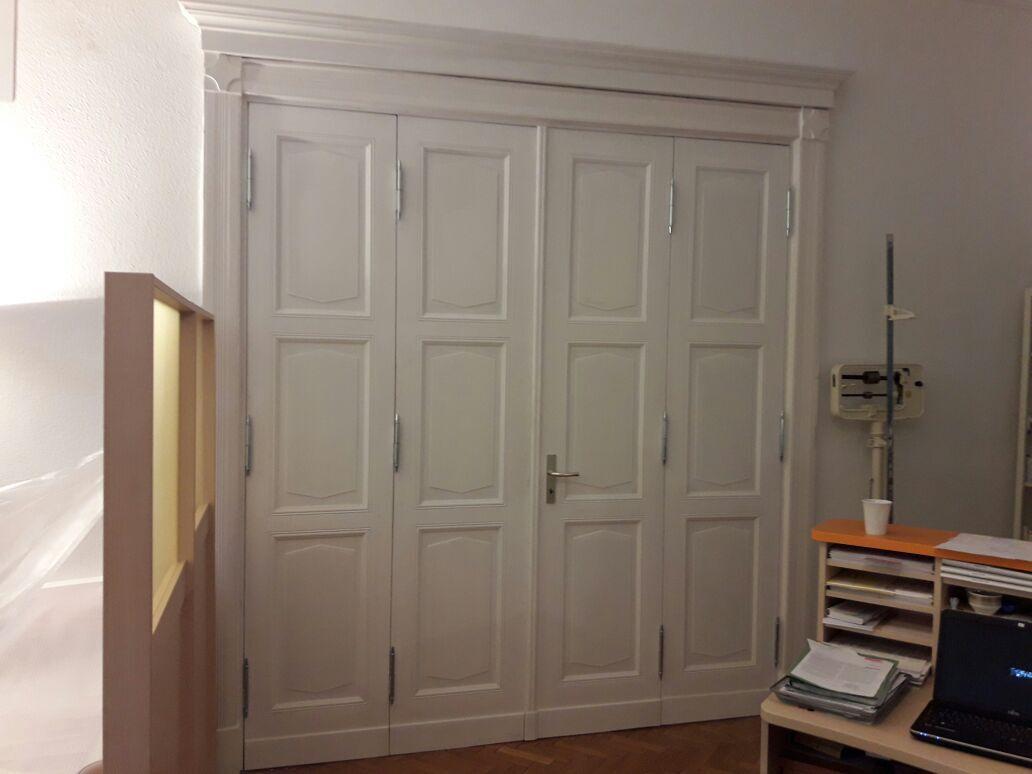 Doppelflügelige Zimmertür mit klassischem Design Weiße doppelflügelige Zimmertür mit stilvollen Verzierungen und eleganter Holzrahmung für ein klassisches Raumambiente.