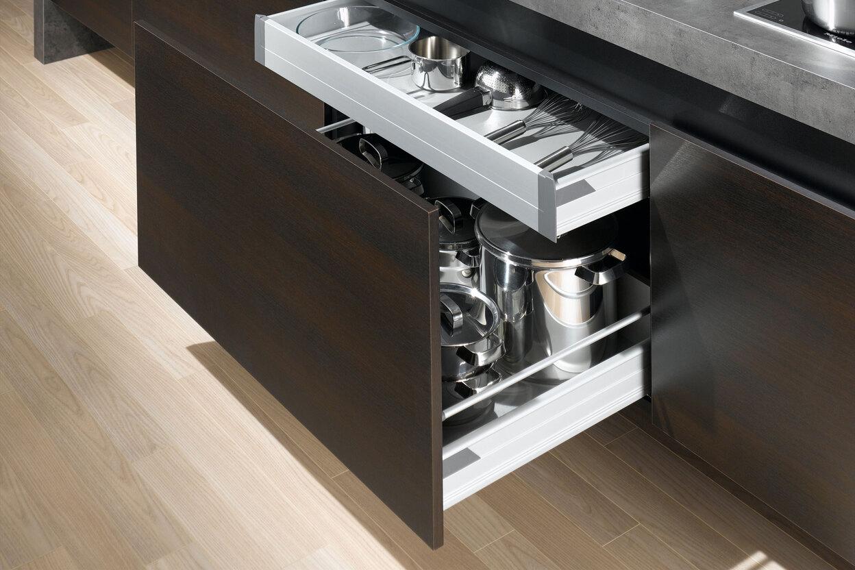 Detailaufnahme von Küchenschubladen mit viel Stauraum in dunklem Holz